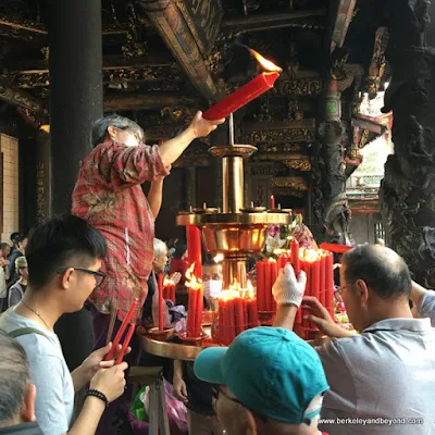 lighting candles at Longshan Temple/Mengjia Longshan Temple in Tapei, Taiwan