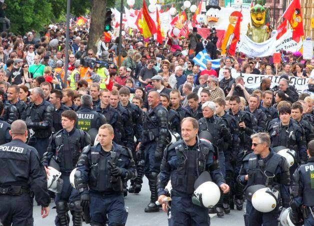 35 moments of violence that brought out incredible human compassion - german riot officers take off their helmets and escort occupy protesters