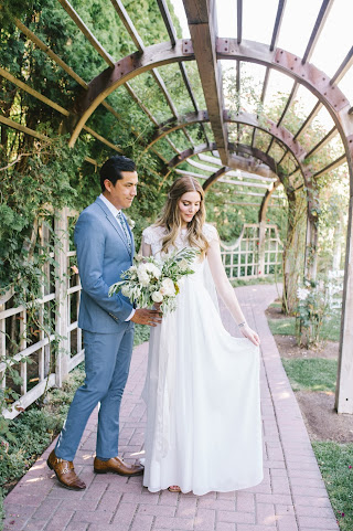 classic bride in a lace dress with a white garden rose and olive bouquet for her classical garden wedding