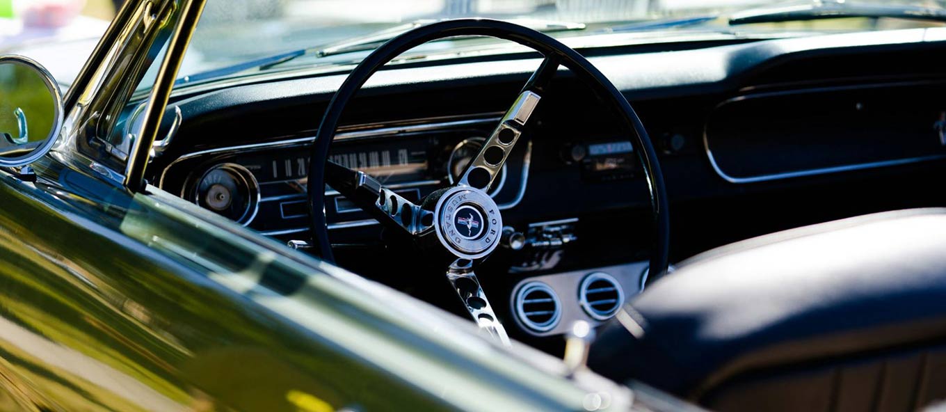 The inside of a muscle car focus on driving wheel