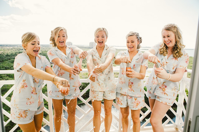 bride and bridesmaids on wedding morning opening champagne