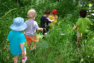 Little kids walking through tall grass