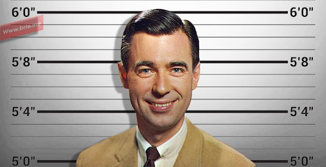 Fred Rogers posing in front of a height chart