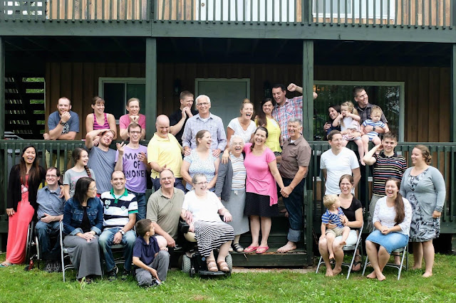 large family picture in front of a house with everyone laughing