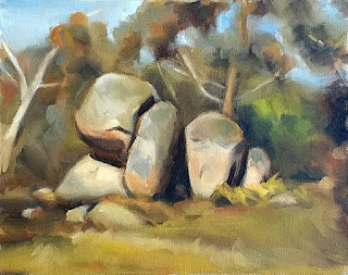 Oil painting of several granite boulders surrounded by eucalpyts.