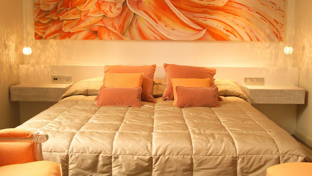 Спальня с оранжевыми подушками и обивкой мебели