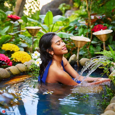 beautiful woman in tropical stream with flowers
