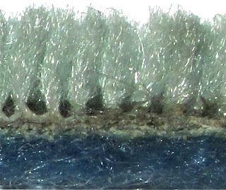 Cross-section of cut pile plush carpet and carpet backing.