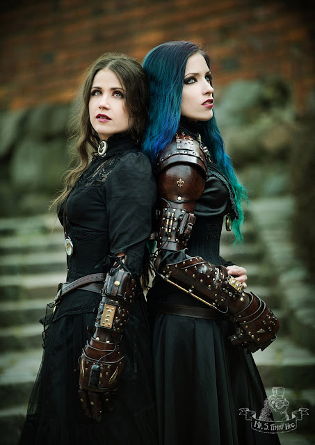 Steamgoths in gothic steampunk clothing (long black dresses, corsets, cameo chokers) with leather gauntlets