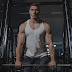 Man in white tank top lifting weights