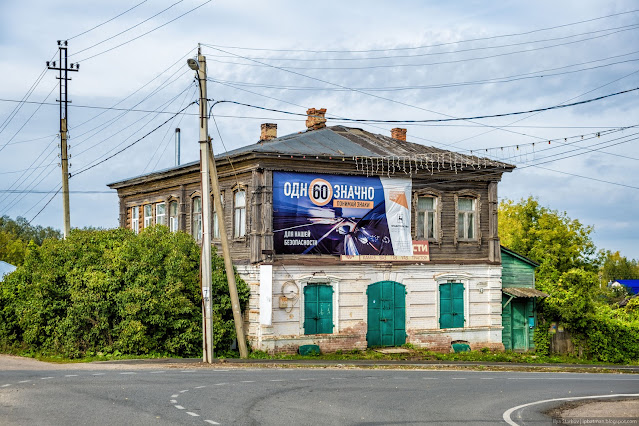 Старинный полукаменный дом с рекламным баннером