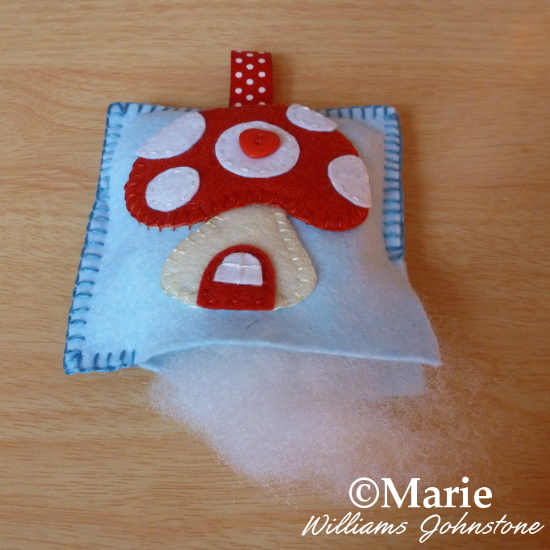 Adding stuffing to the felt pincushion plush