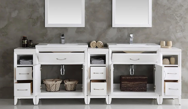 Large double vanity with lots of storage with the doors open showing the plumbing.