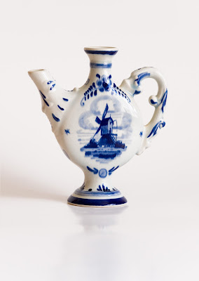 A small blue delft jug with a windmill design.