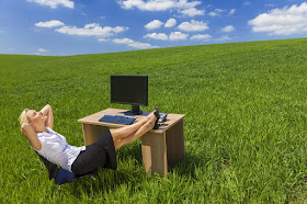 Photo d’une femme rêvant dans son bureau d’une prairie verte.