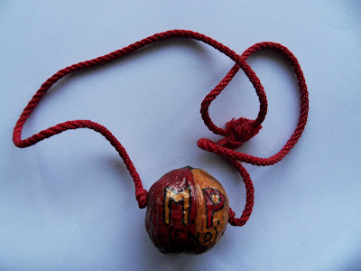 Painted walnut on a string cord