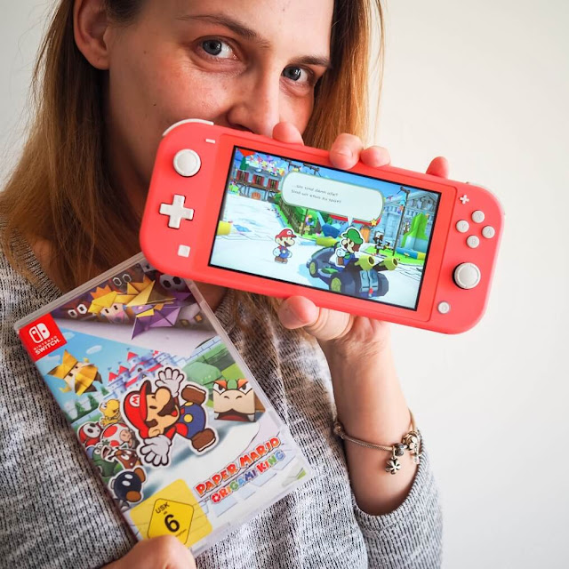 Paper Mario Origami King und Nintendo Switch Lite Konsole in der Farbe Koralle