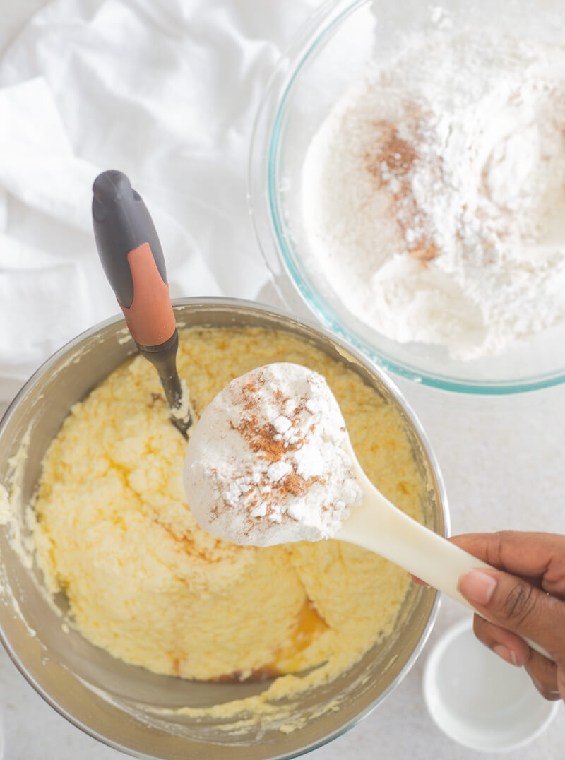 Picture of adding flour and spices to creamed butter and sugar.
