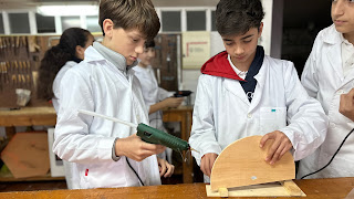 Alumnos en el taller de tecnología usando pistola de silicona