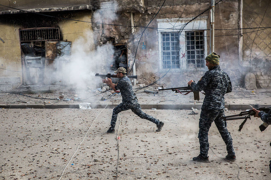 Powerful Heart-Breaking Pictures Of The Battle Of Mosul - Federal Police fire at Islamic State positions at the end of the street in the Old City