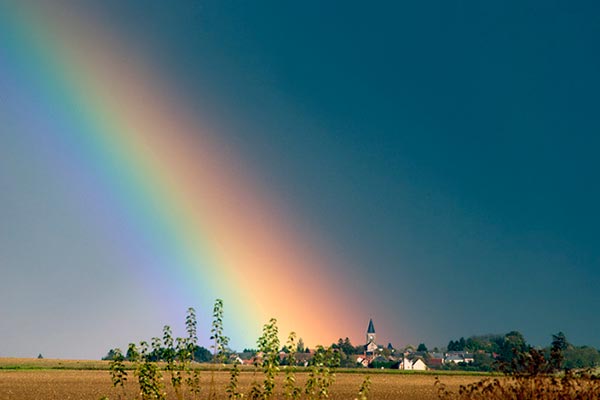 Un pueblo bajo un gran arco iris.