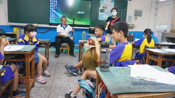 ▲許村和老師為華南國小學生示範認識高甲戲曲樂器操作。（記者林明佑翻攝）