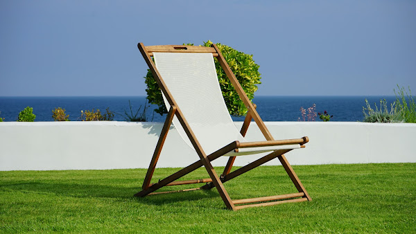 white sling chair sitting on perfectly manicured green grass