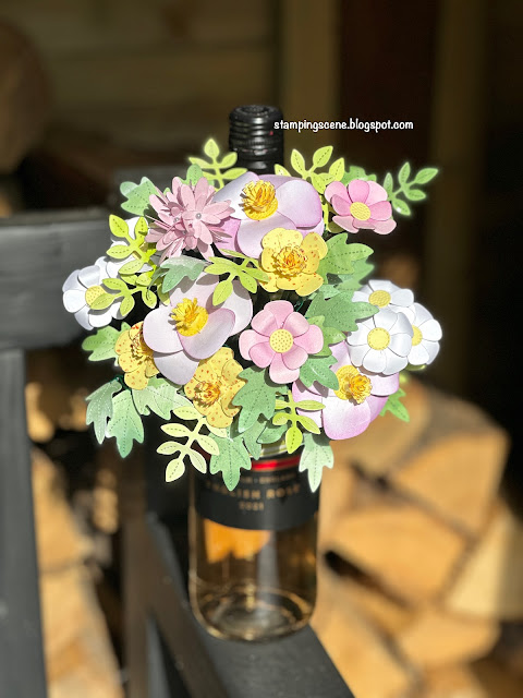 paper flower bouquet in a bottle holder on a bottle of wine