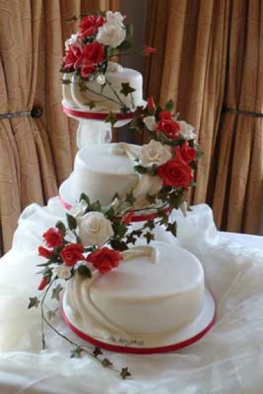 Three tier white cake with cascade red and white roses