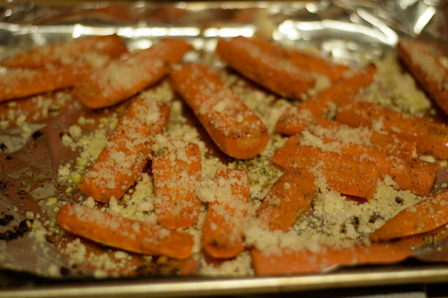 The carrots sprinkled with parmesan cheese on the baking sheet. 