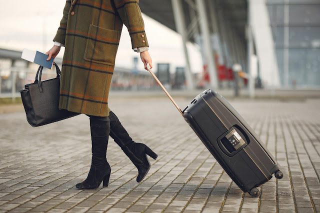 woman walking through airport with luggage