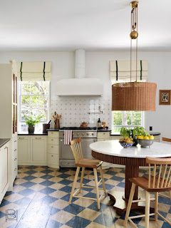 Beata Heuman traditional kitchen with blue diamond painted wood floors, modern white oven hood, and oversized rattan pendant light over table