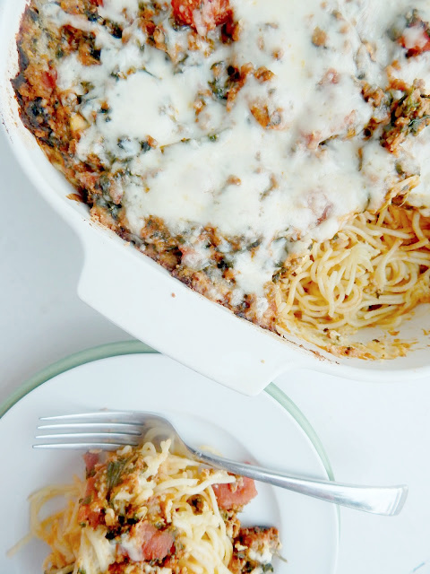 Aerial shot of baked spaghetti in a white baking dish and plated on a white dinner plate.