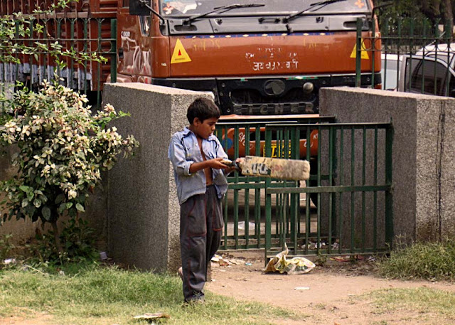 child batting while playing cricket