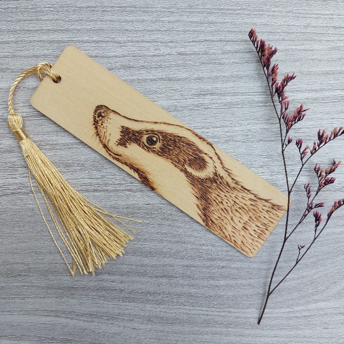 I got my dad to create some of his wood bookmarks for my favourite book  series. He carefully burns the design into the wood by hand using an  artistic technique called pyrography. 