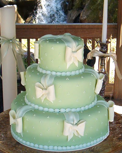 Three tier pastel green icing wedding cake with cute white bows