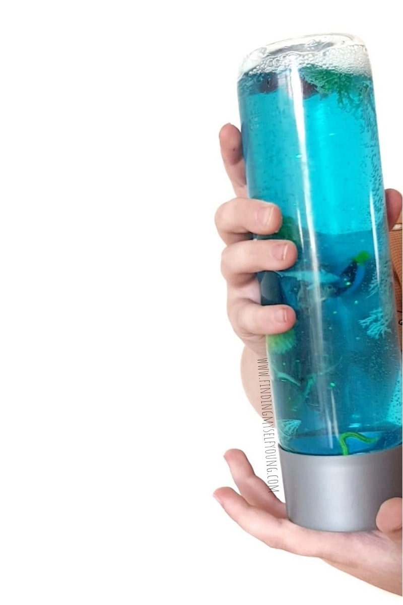 coral reef sensory bottle held in childs hands