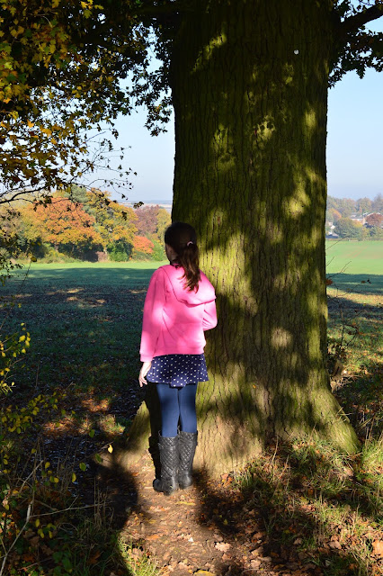 Girl hiding behind a tree