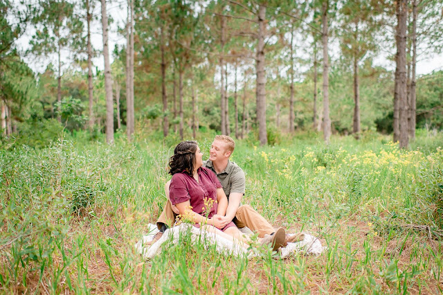 couple sitting in a field on a blanket