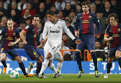 Raphael Varane surrounded by four Barcelona players