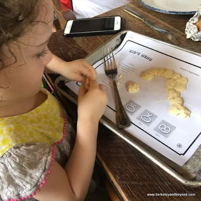 little girl plays with pretzel dough at Southerleigh Fine Food and Brewery in San Antonio, Texas