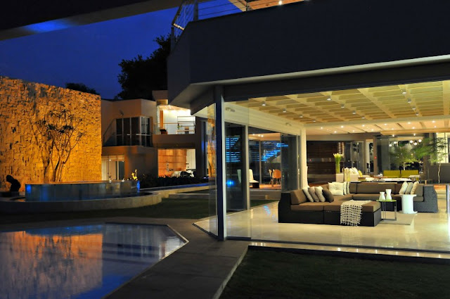 Photo of open living room by the pool at night