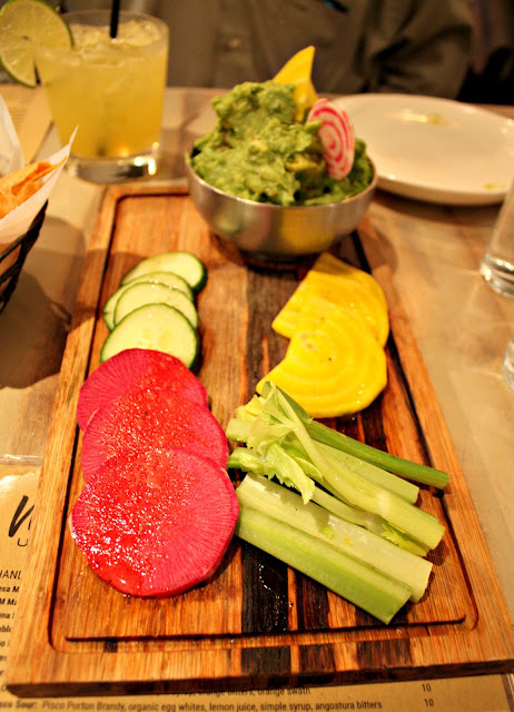 Fresh and healthy guacamole plate at Mesa Urbana featuring vibrant dipping vegetables.