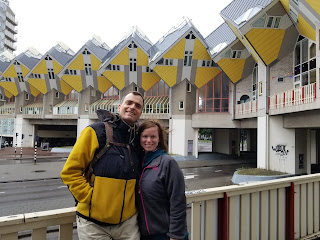 man and woman standing in front of yellow cube houses in Rotterdam