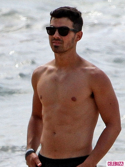 Nick Jonas and Joe Jonas play football on the beach in Hawaii on April 20 