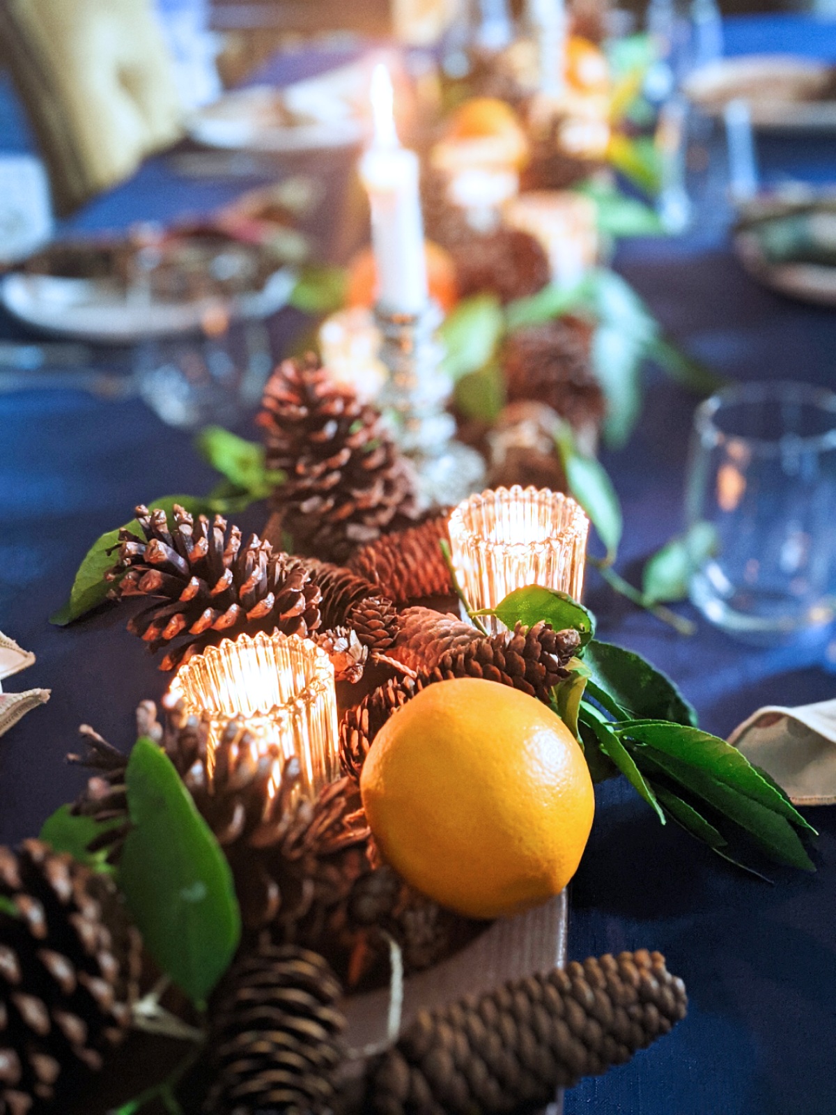CAD Interiors dining table setting holidays fruit lemons pinecones pine garland candles natural