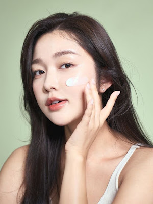Mulher coreana aplica creme coreano no rosto para rotina K beauty