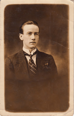 Black and white portrait of a man wearing a suit and tie.