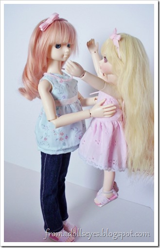 A doll lifting up another doll.