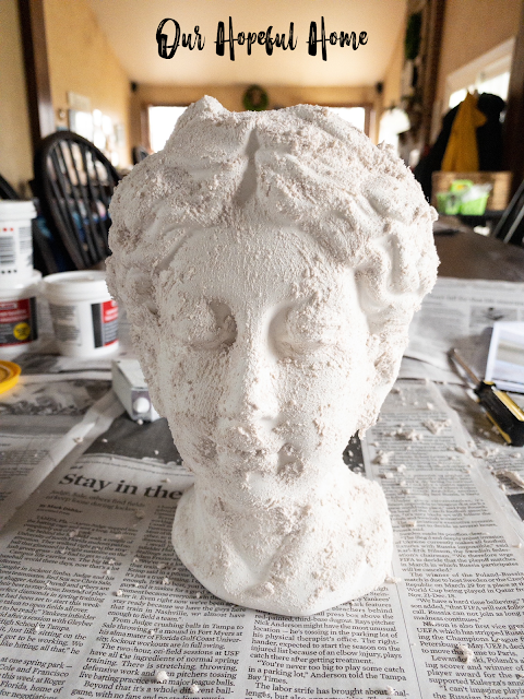 Grecian urn planter head smeared in stucco patch to look like aged concrete